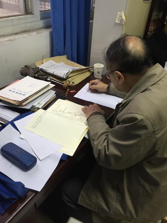 学院退休老教师张弘逊正在检查教案