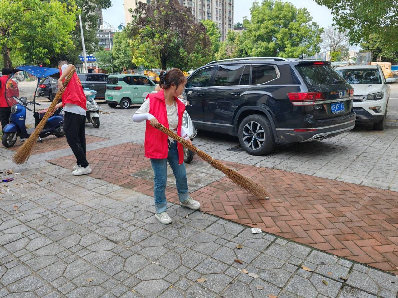 图1为志愿者们清扫社区路面 图1为志愿者们清扫社区路面